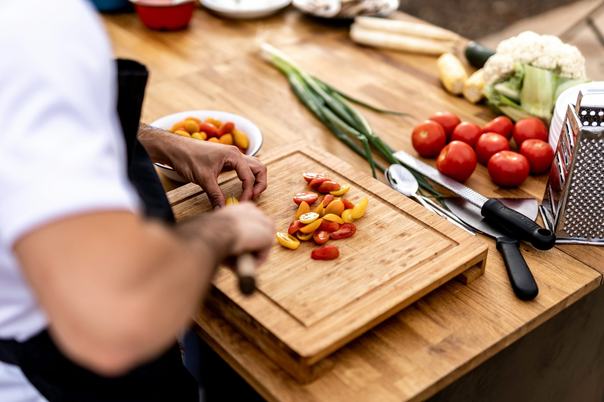 Una persona cortando verduras en una tabla de cortar